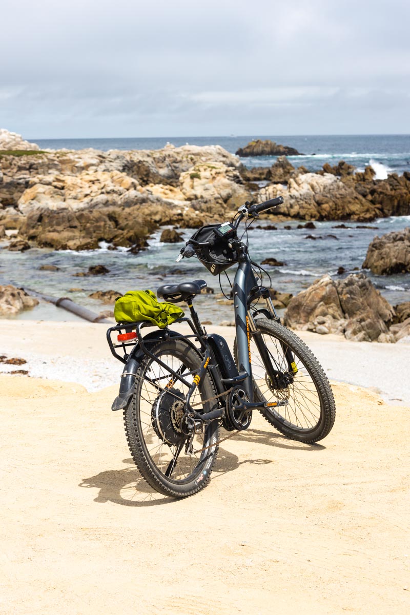 A bike on it's stand beside a beach along the Monterey Bay Coastal trail.