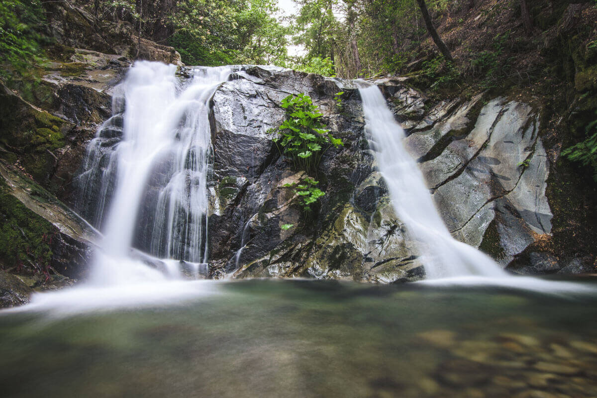 A long exposure image of the two waterfalls of Brandy Creek Falls flowing over rocks.