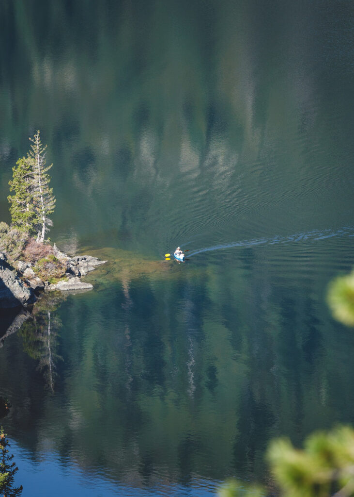 A man kayaking on on a calm and flat Castle Lake.