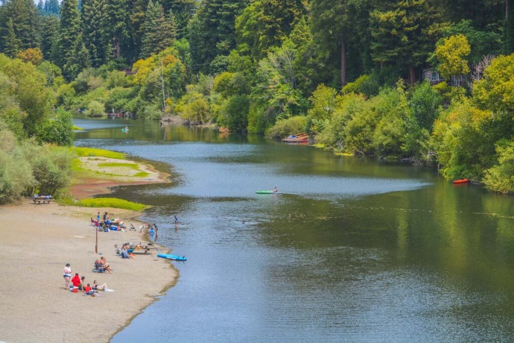 Crowds of people relaxing next to the Russian River in Sonoma Coast State Park.