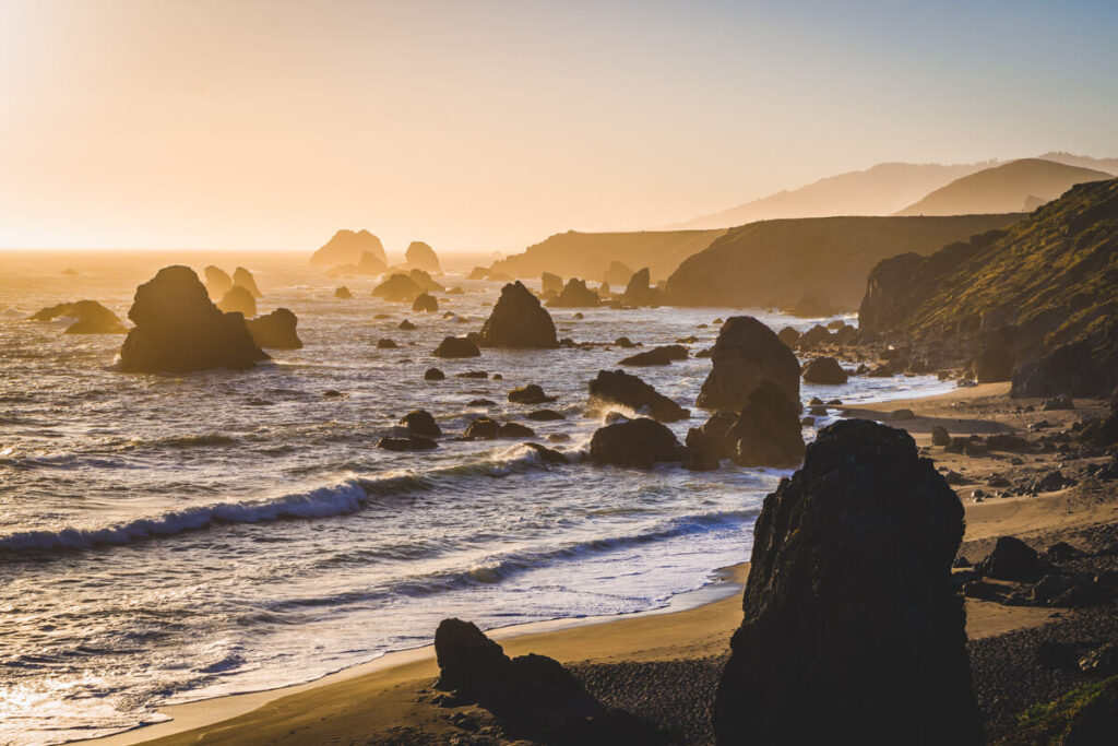 A beautiful soft sunset over a group of sea stacks seen from the Kortum Trail in Sonoma.