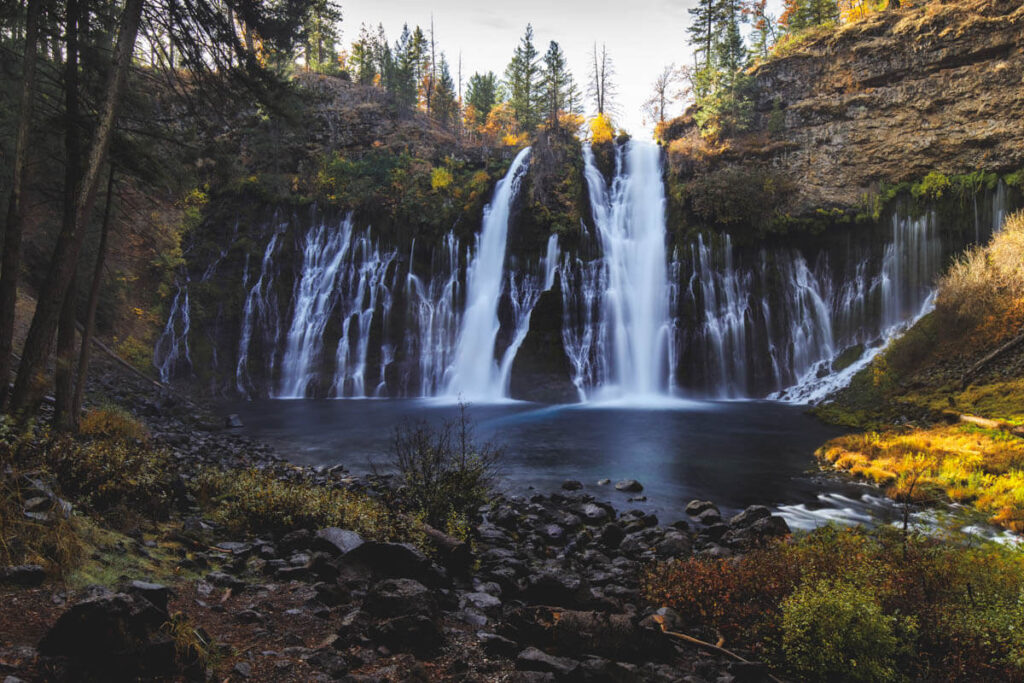 The huge Burney Falls surrounded by fall colors in McArthur Burney Falls state park.