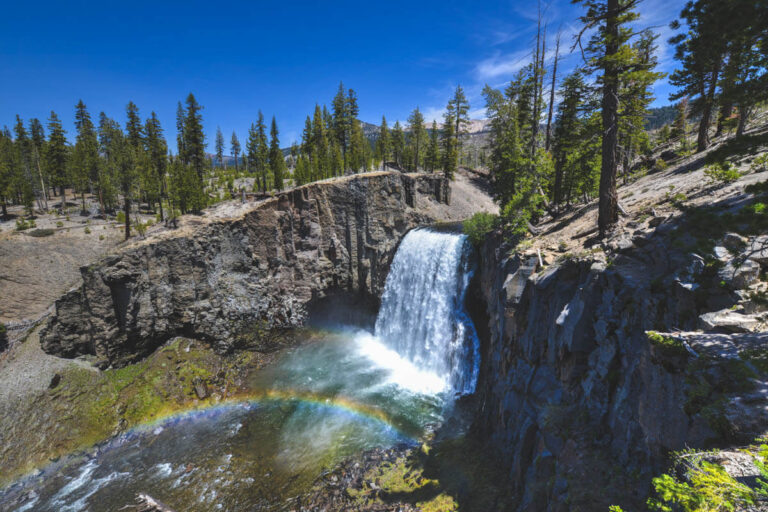 A distant view of Rainbow Falls as the spray from the waterfall creates a rainbow.