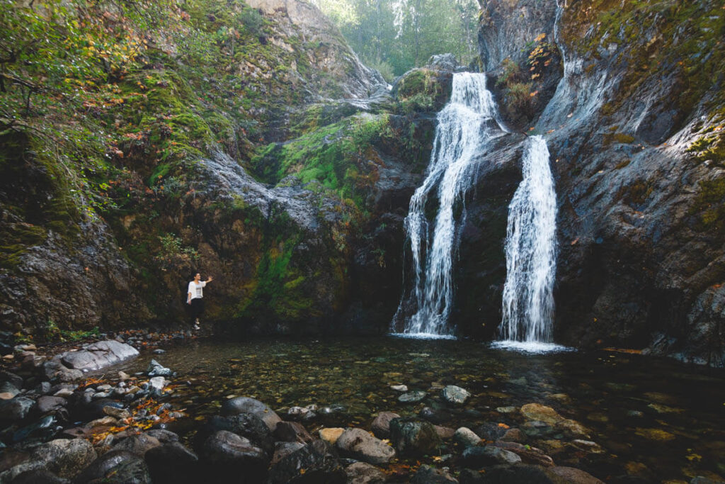A tourist stands next to Faery Falls in Mount Shasta, Northern California.