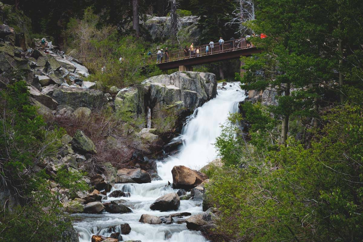 Many tourists crossing the bridge over the top of Eagle Falls in Northern California.