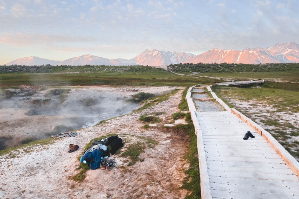 A pile of clothes left besides the hot springs with a view of the Sierra Nevada mountains in the distance.