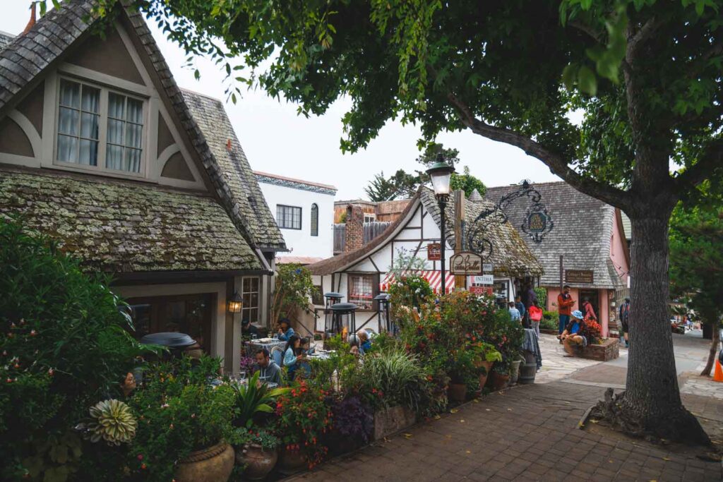 A fairytale looking village with old houses and signs for the local shops in Carmel-by-the-Sea.