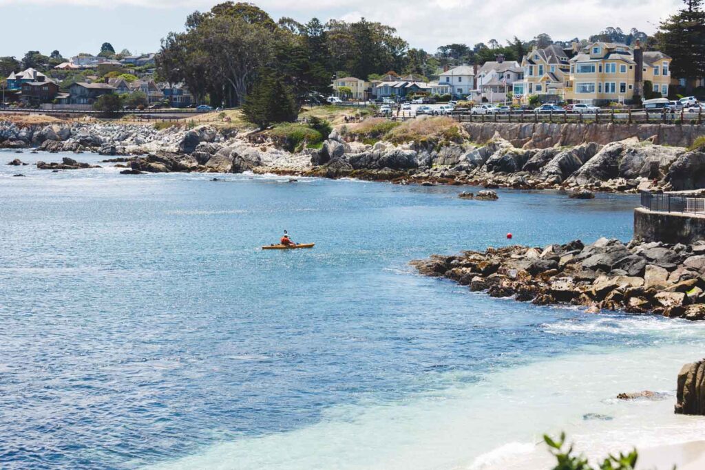 A kayaker enjoying his day on the waters of Monterey Bay besides the town.