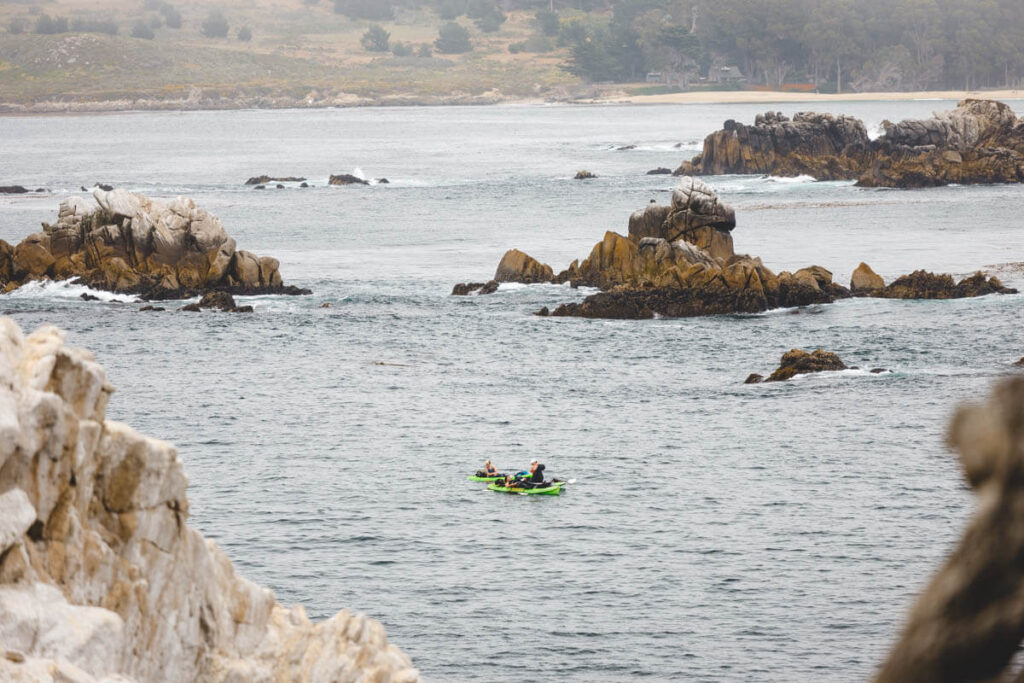 Three kayakers hanging out in the ocean at Point Lobos State Natural Reserve.