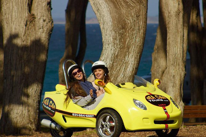 Two girls in a small yellow car on a Monterey sea cars tour.