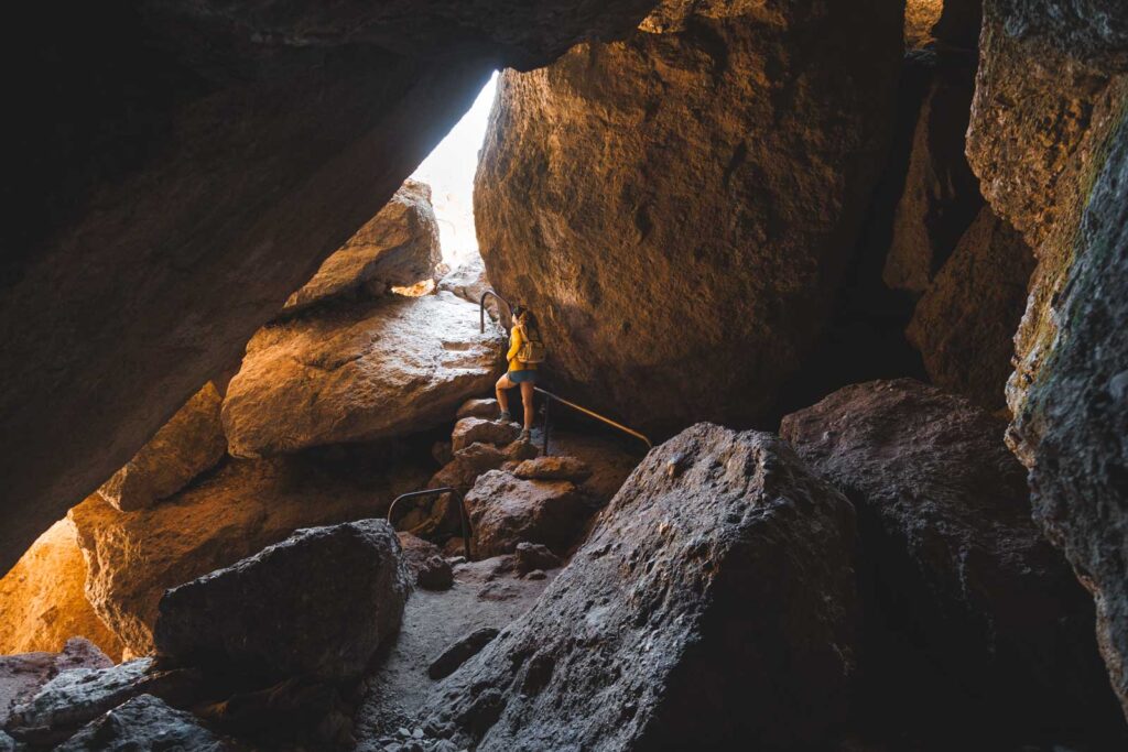 Nina climbing up to an exit from a cave along the Balconies Trail in Pinnacles National Park.