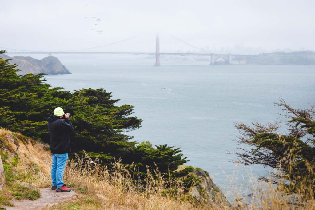 Garrett taking a photo of the Golden Gate Bridge from a distance.