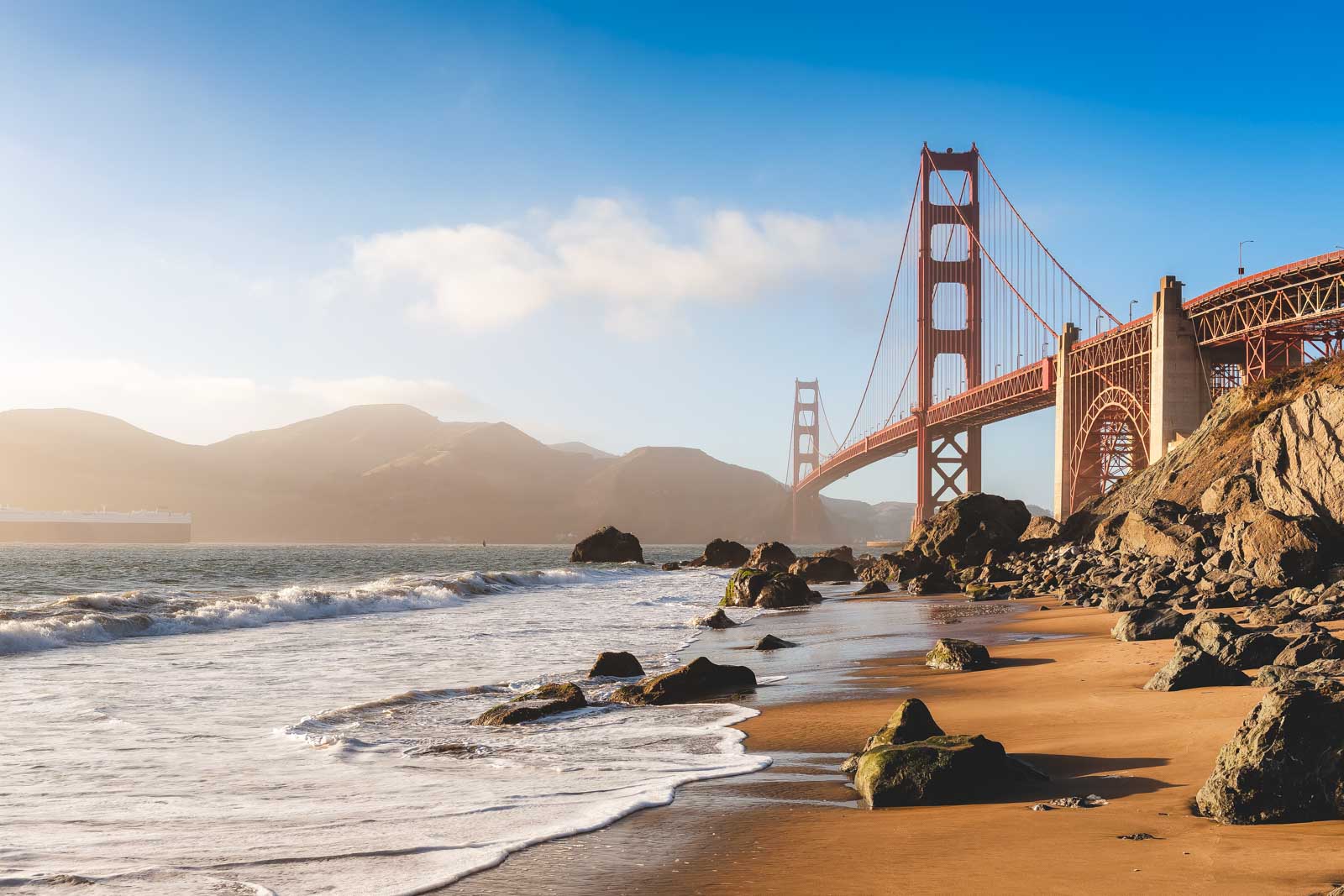 A viewpoint of the Golden Gate Bridge from Marshall's Beach at golden hour.