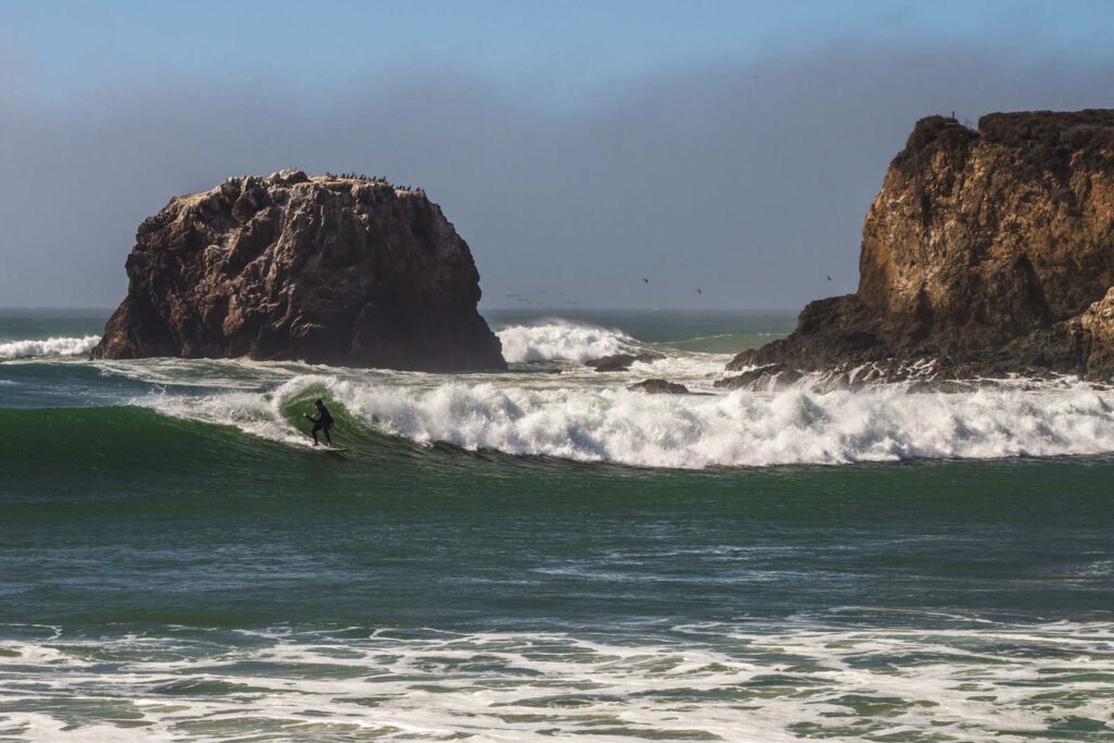 A surfer on a barrel wave in Andrew Molera State Park near Monterey.