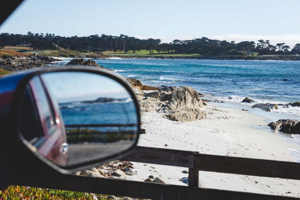 A view from a car window looking at a beach along the 17 Mile Drive in Monterey.