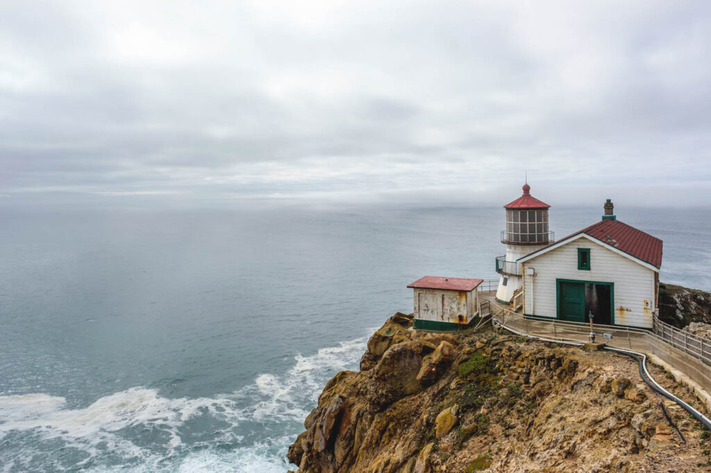 Point Reyes Lighthouse on a cliffside on an overcast day.
