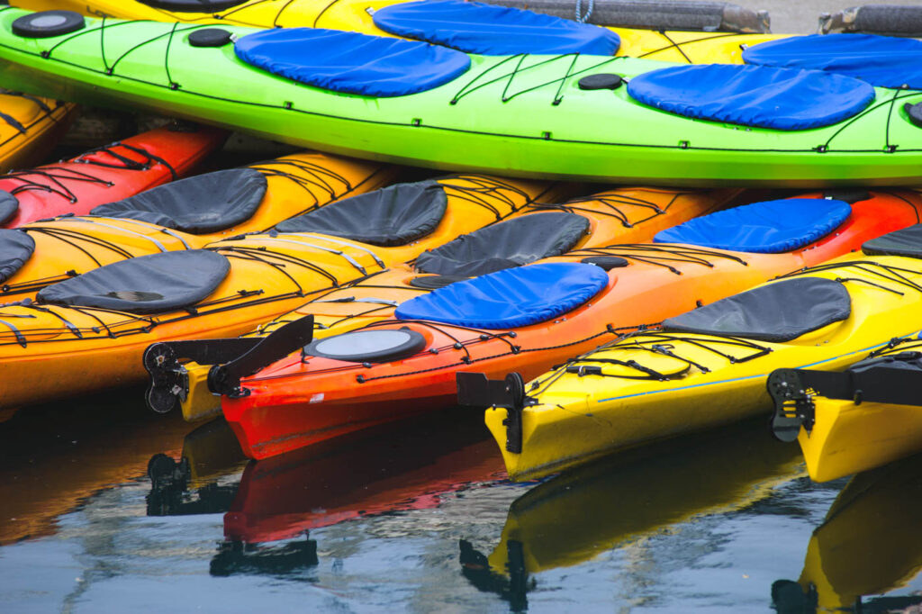 Different colored kayaks stacked on each other.
