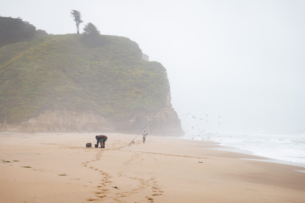 Two fishermen on Pomponio State Beach on a foggy Half Moon Bay day.