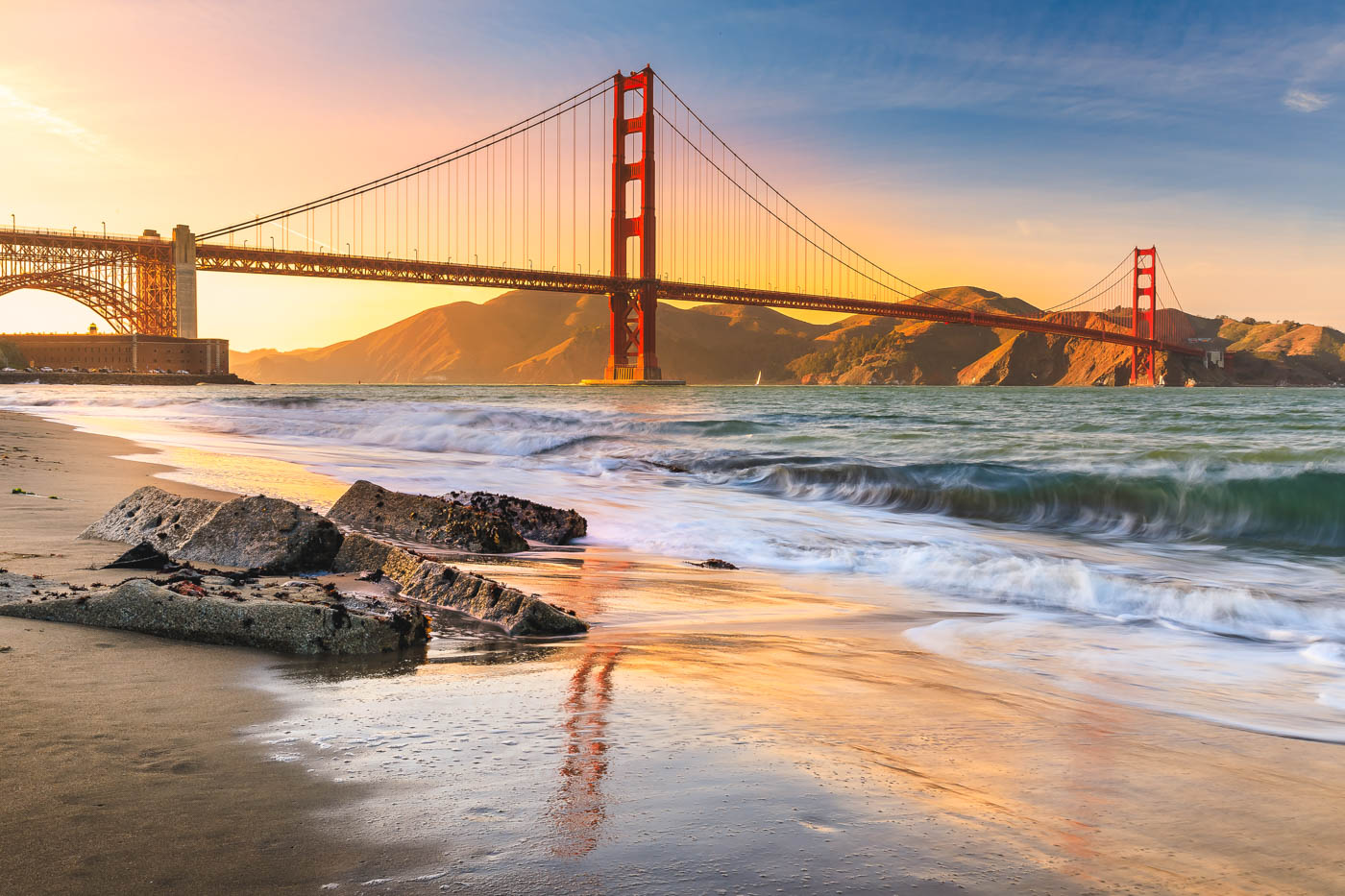 Sunrise glow behind the Golden Gate Bridge from Golden Gate Beach.