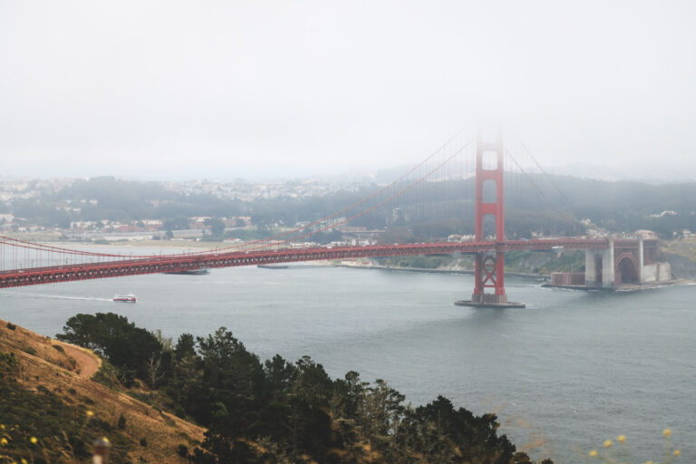 A ferry sailing underneath the Golden Gate Bridge on an overcast day in San Francisco.