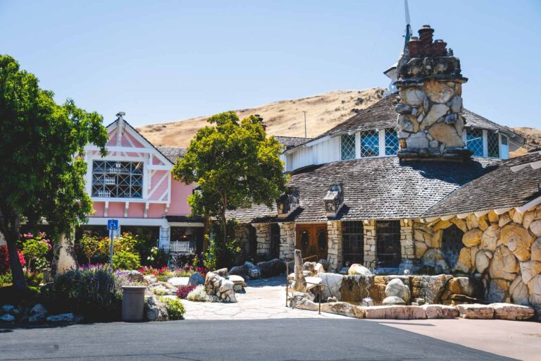 Unique looking Madonna Inn accommodation with ston walls and a hill behind it in San Luis Obispo.
