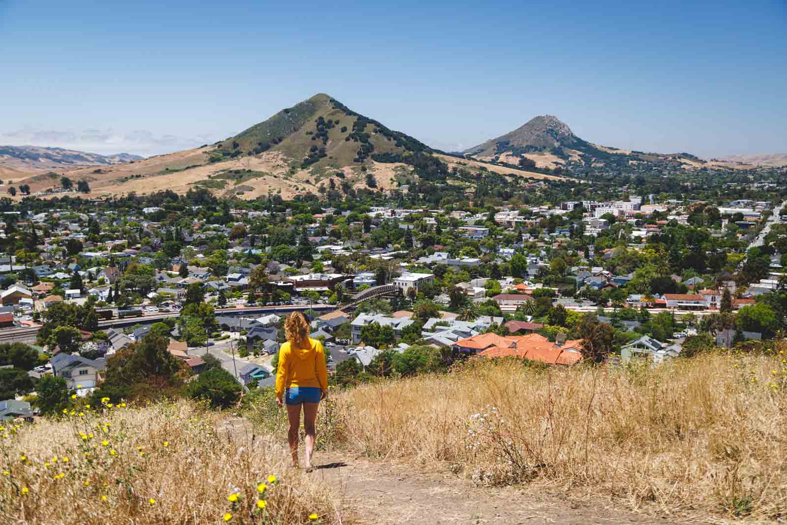 Nina hiking along a trail in the Terrace Hill Open Space with a view over San Luis Obispo town and beyond.