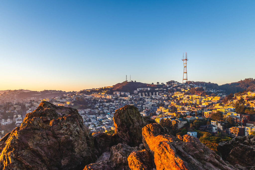 An area of San Francisco bathed in orange golden hour light from the Corona Heights hiking trail.