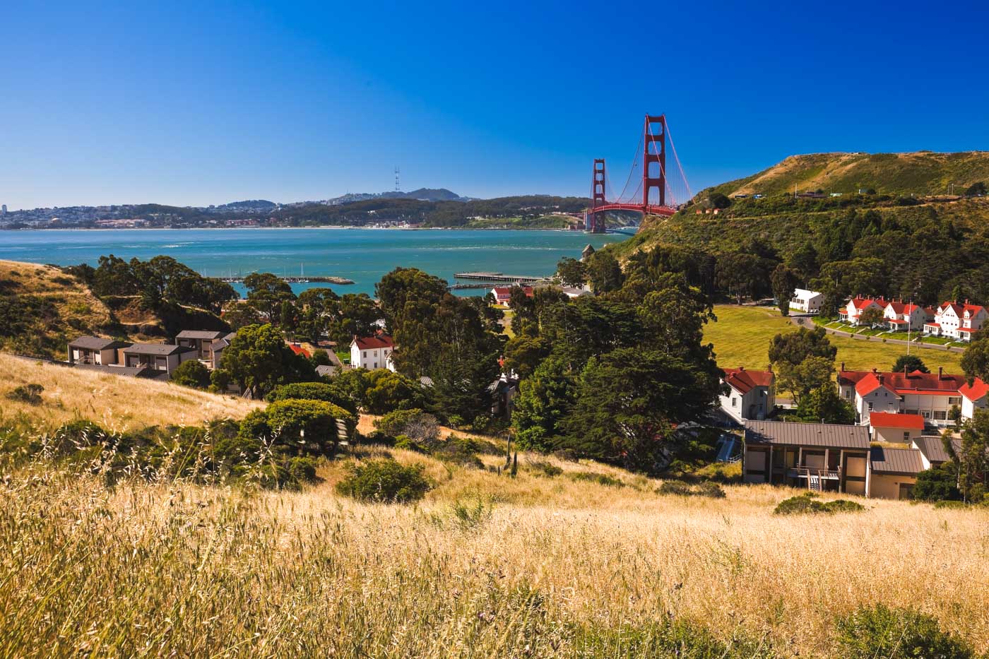 View of Fort Baker besides houses and the Golden Gate Bridge in San Francisco on the sunny day.