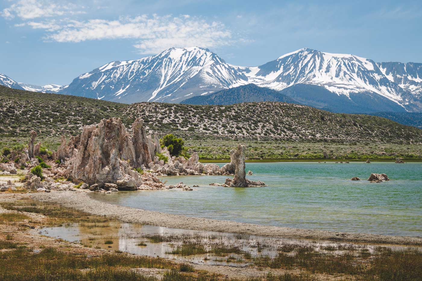 Petrified towers of salt on the shores of Mono Lake with a backdrop of snow covered mountains.