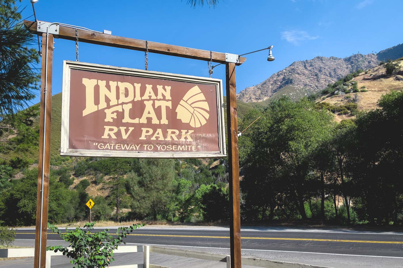 Entrance sign to Indian Flat RV Park in the Yosemite mountains on a sunny day.