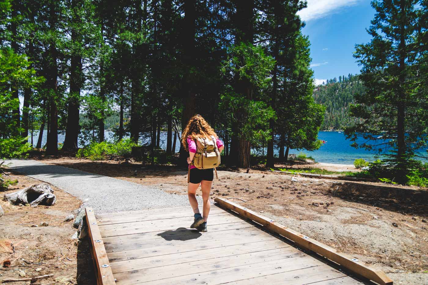 Nina crossing a small wooden bridge along the Rubicon Trail besides the lake of Emerald Bay.