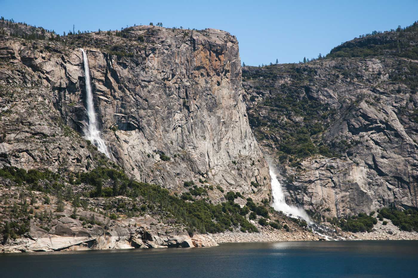 A view of Tueeulala Falls and Wapama Falls next to each other in the mountains of Yosemite.