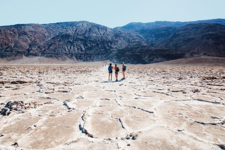3 people standing on the dry salt flats at the Badwater Basin Trail.