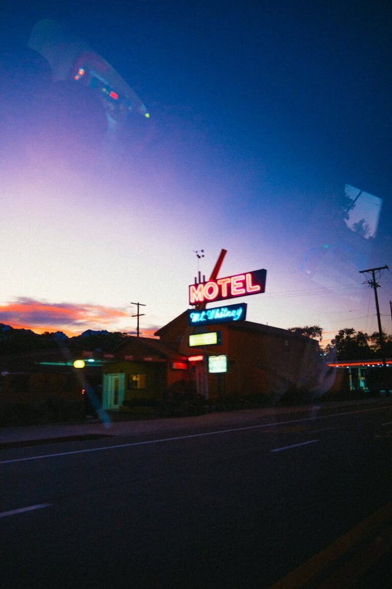 A classic neon sign lights up a roadside motel at twilight, creating a nostalgic atmosphere.